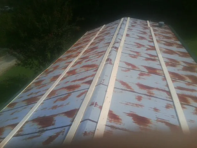 Rusted metal roof panels with new wood purlins before replacement — Storm Damage Roof Repair in Fisher by Roofing Brothers