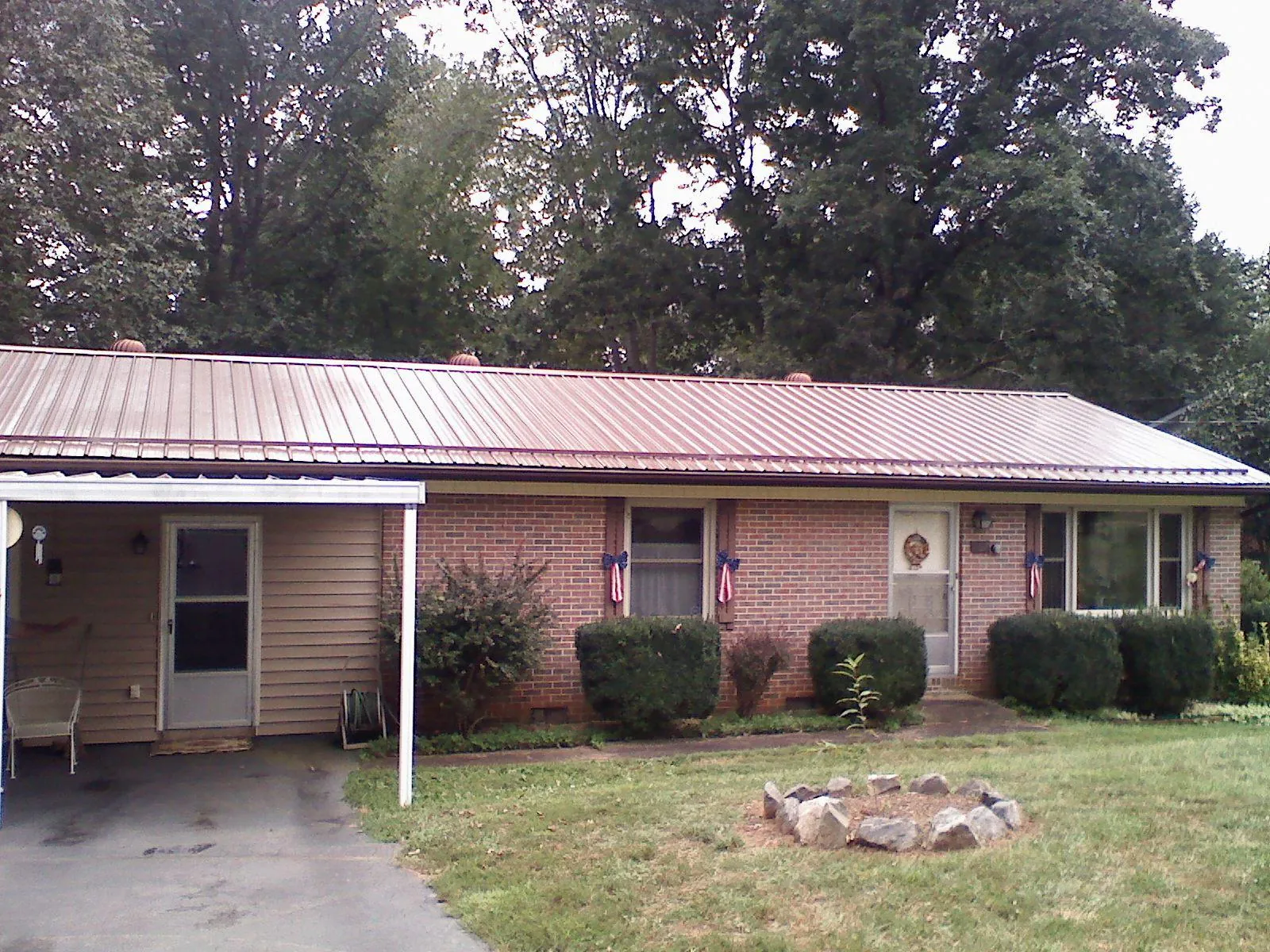 Bronze metal roof and carport on a brick ranch home — Roof Repair work by our crew in Fisher